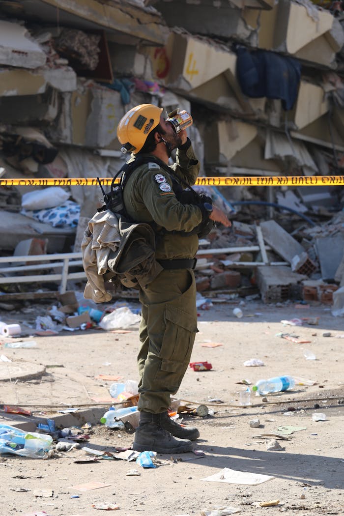 our-story Rescue worker amidst urban rubble post-earthquake, assessing damages.