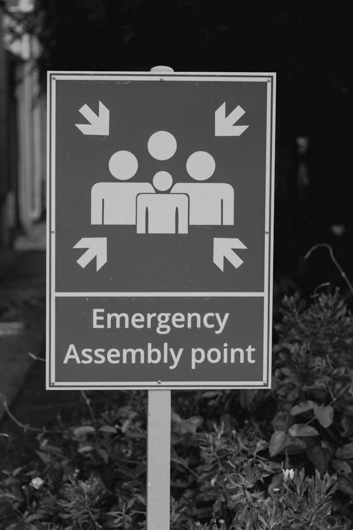 gallery-02 Monochrome image of an emergency assembly point sign outdoors.
