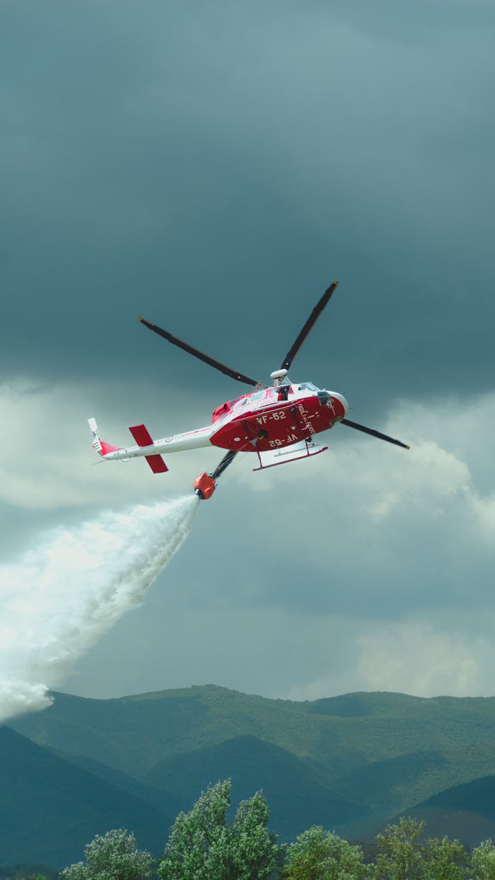 gallery-05 Aerial view of a firefighting helicopter dropping water over a forest in Abruzzo, Italia.