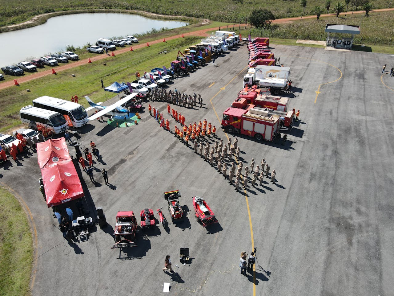 Aerial view of a firefighter training event showcasing various emergency vehicles and personnel in formation.